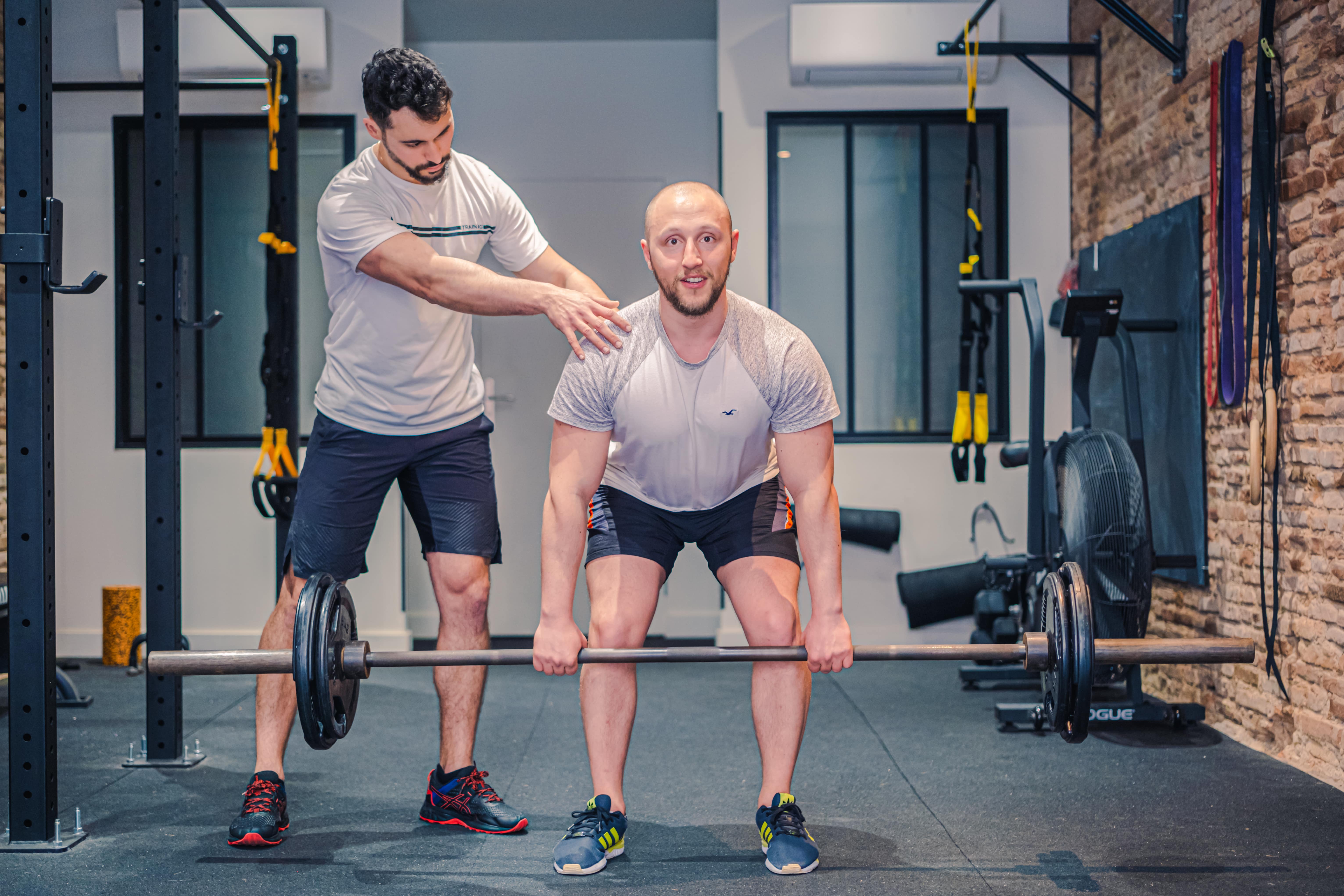 Séance de coaching individuel où le coach montre comment exécuter les exercices