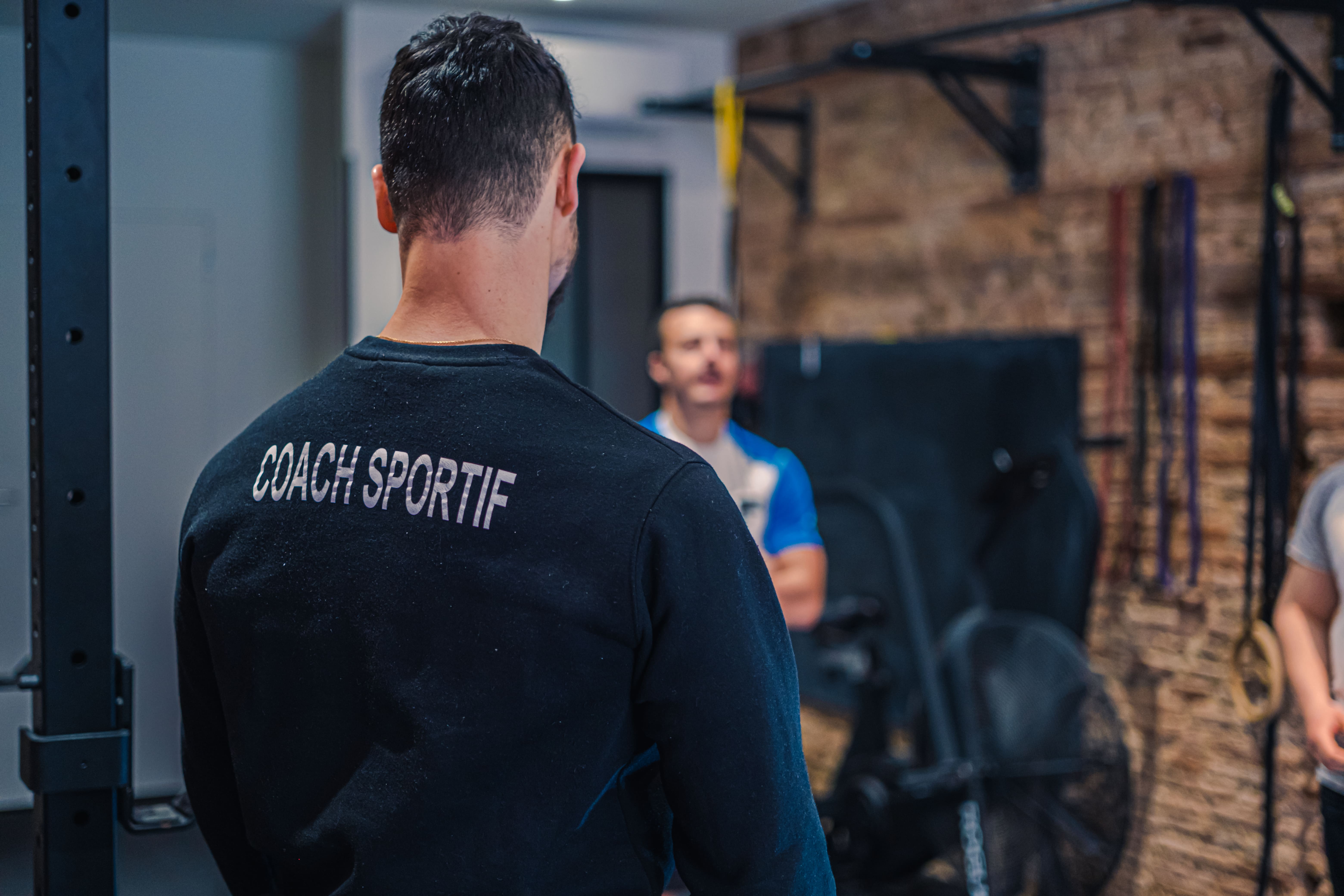 Séance de coaching en groupe où le coach montre comment exécuter les exercices